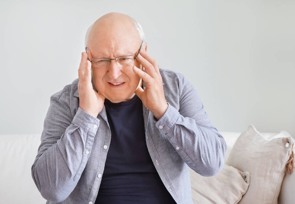 Senior leidet zu Hause unter Kopfschmerzen - Foto, Bild