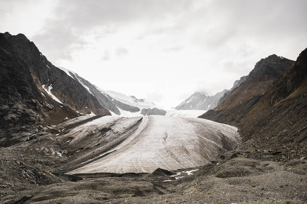 Majestueuze koude gletsjer in de bergen op weg naar de top van Aktru. Besneeuwde stenen hellingen van het Altai-gebergte. De ongerepte schoonheid van de natuur. Siberië. Rusland. - Foto, afbeelding