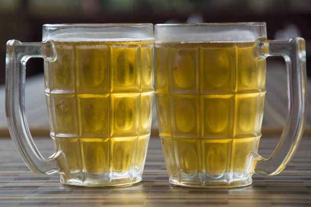 Deux tasses de bière réfrigérée sur une table
 - Photo, image