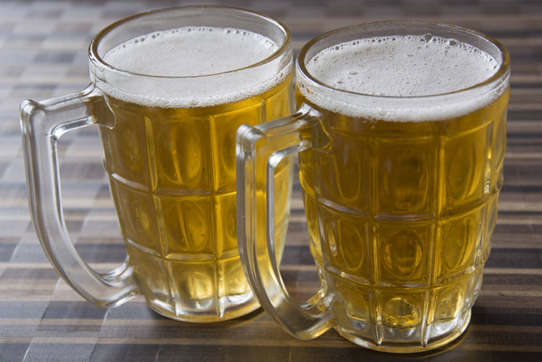Two Mugs of Chilled Beer on a Table - Фото, изображение