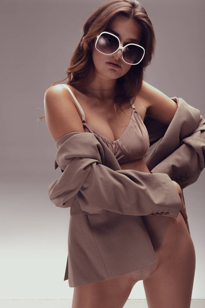 Menina fina bonita em óculos retro em lingerie e uma jaqueta
 - Foto, Imagem