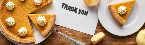 Draufsicht auf leckeren Kürbiskuchen, Äpfel und Dankeskarte auf rustikalem Holztisch, Panoramaaufnahme - Foto, Bild