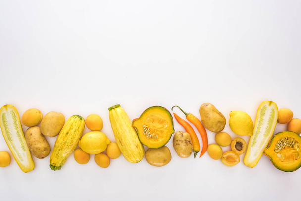 felső nézet a sárga gyümölcsök és zöldségek fehér alapon - Fotó, kép