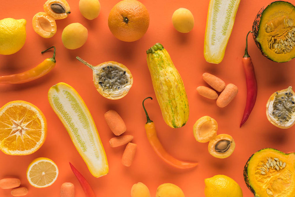top view of yellow fruits and vegetables on orange background - Foto, Bild