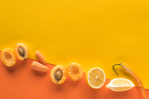 felülnézet friss gyümölcsök és zöldségek sárga és narancssárga háttér másolási hely - Fotó, kép