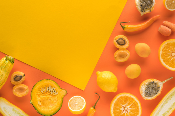 top view of fresh fruits and vegetables on yellow and orange background with copy space - Photo, image