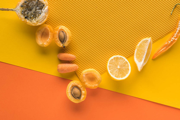top view of fresh fruits and vegetables on yellow and orange background with copy space - Foto, afbeelding