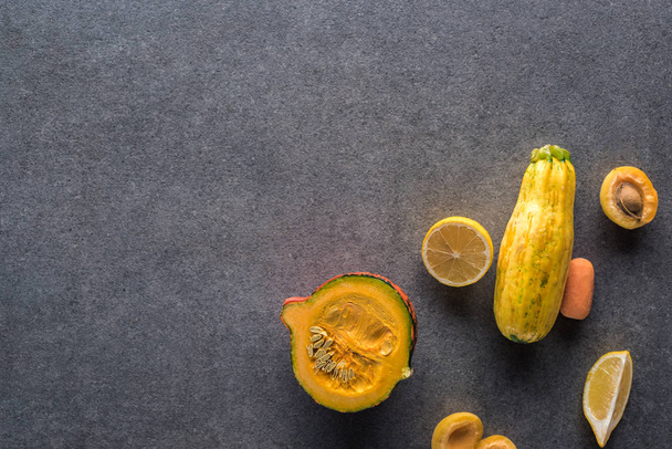 bovenaanzicht van geel fruit en groenten op grijze textuur achtergrond met kopieerruimte - Foto, afbeelding