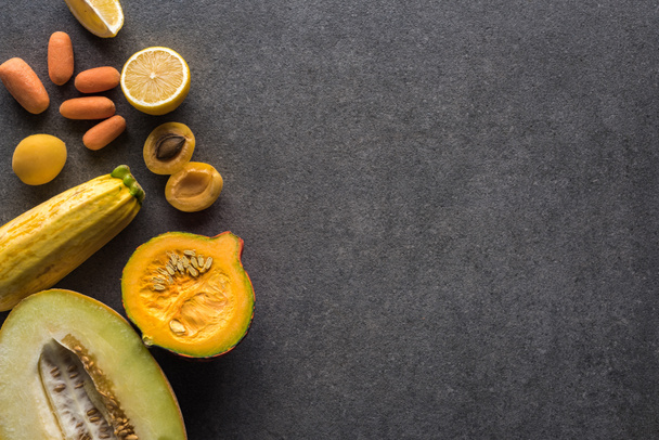 vista superior de frutas e legumes amarelos em fundo texturizado cinza com espaço de cópia
 - Foto, Imagem