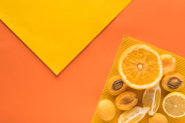 top view of yellow fruits on yellow and orange background with copy space - Photo, Image