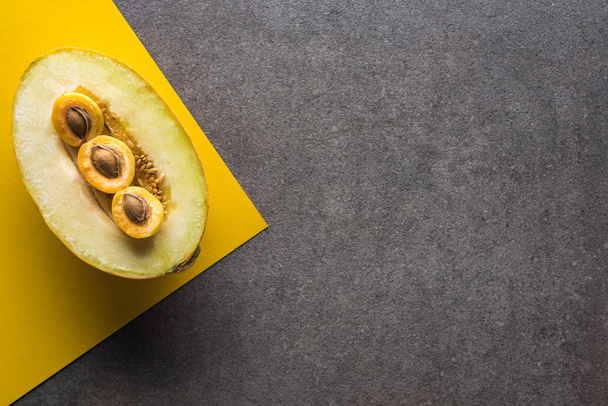 top view of melon and apricots on yellow and grey background with copy space - Foto, Imagem