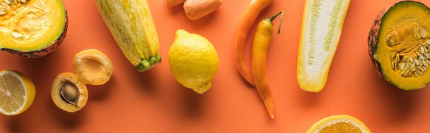 vista superior de frutas y verduras amarillas sobre fondo naranja, plano panorámico
 - Foto, Imagen