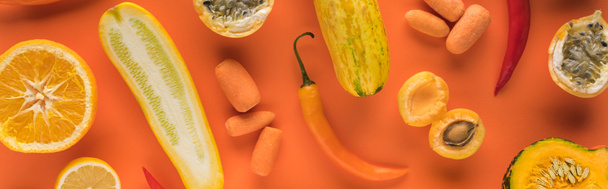 top view of yellow fruits and vegetables on orange background, panoramic shot - Foto, afbeelding