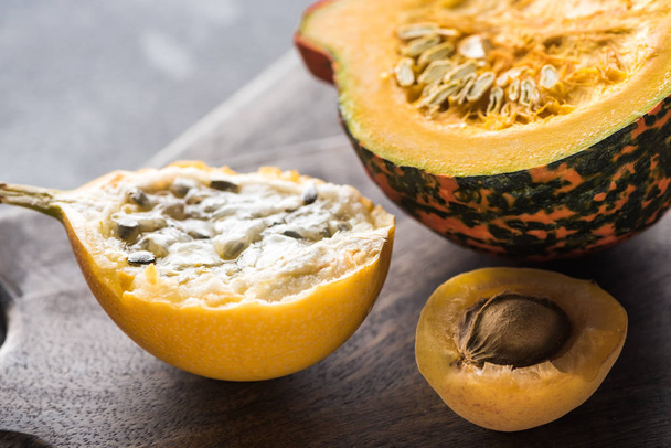 close up view of yellow sweet granadilla, pumpkin and apricot on wooden chopping boards - Foto, immagini