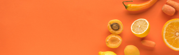 vista superior de frutas e legumes amarelos no fundo laranja com espaço de cópia, tiro panorâmico
 - Foto, Imagem