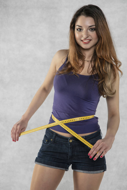 young athletic female silhouette, measure tape - Foto, Imagen