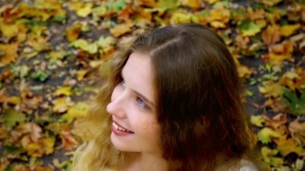 Gezicht van meisje en hals met herfst bladeren in Park - Video