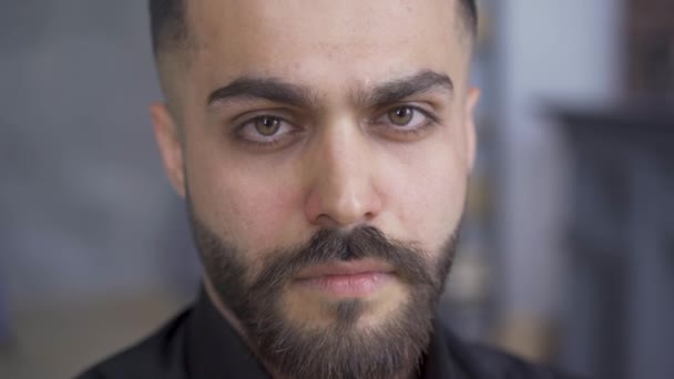 Serious brunette man with beard and mustaches looking at the camera. Portrait of attractive caucasian man in black shirt. - Materiał filmowy, wideo