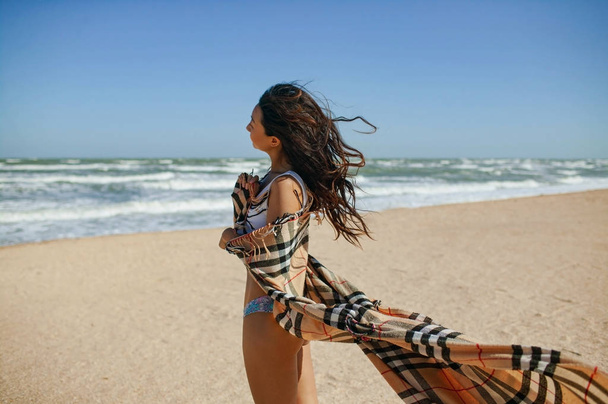 海を背景にした若い女性。風に髪が吹く.  - 写真・画像