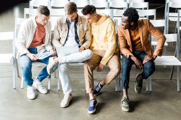 чотири молодих мультикультурних бізнесмени обговорюють стартап-проект, сидячи в конференц-залі
 - Фото, зображення