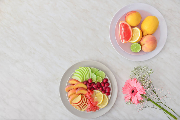 Assiettes avec des fruits frais savoureux sur la table lumineuse
 - Photo, image