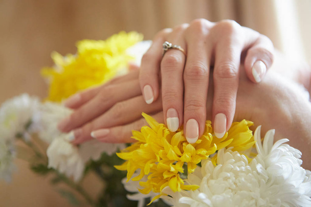 Όμορφα χέρια των γυναικών στο φόντο των λουλουδιών. Φρενκ - Φωτογραφία, εικόνα