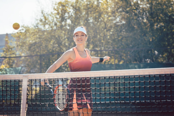 Mujer en vestido deportivo rojo jugando tenis - Foto, Imagen