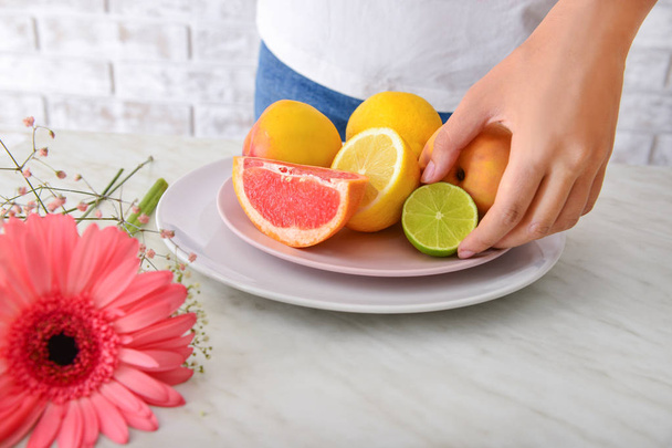 Женщина со свежими фруктами на столе, крупный план
 - Фото, изображение
