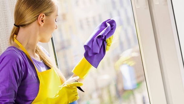 Girl cleaning window at home - Фото, зображення