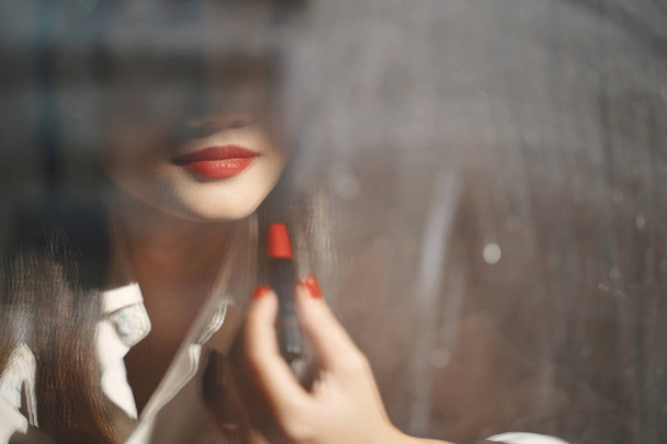 Młoda Azjatycka atrakcyjna kobieta stosujące czerwoną szminkę makijaż, odzwie - Zdjęcie, obraz
