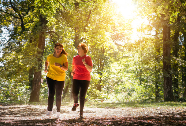 Two middle aged women running  - Foto, Bild