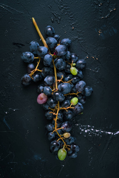 Bunch of blue grapes on dark blue background - 写真・画像
