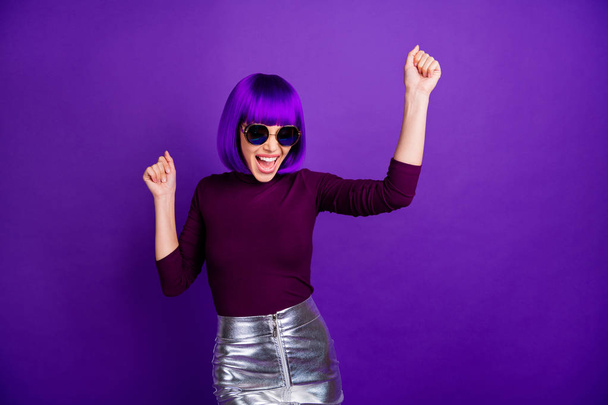 Portrait of cheerful lady with raised fists screaming yeah wearing eyeglasses eyewear isolated over purple violet background - Foto, Imagen