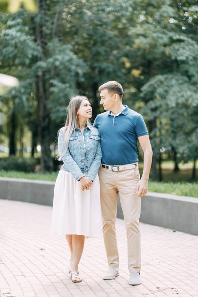  Happy people enjoy the good weather. Beautiful couple walking in the Park in the summer. - Zdjęcie, obraz
