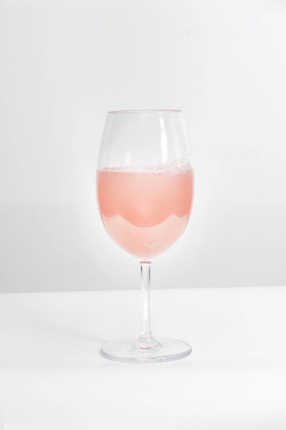 A cup of rose wine on a white table and background - Foto, immagini