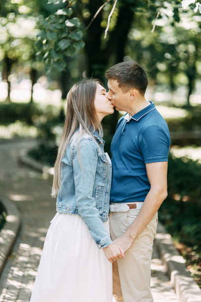  Happy people enjoy the good weather. Beautiful couple walking in the Park in the summer. - Zdjęcie, obraz
