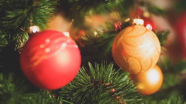 Noel ağacında iğneler ve renkli süs eşyaları yakından tonda fotoğraf. Kış tatilleri ve kutlamalar için mükemmel arka plan - Fotoğraf, Görsel