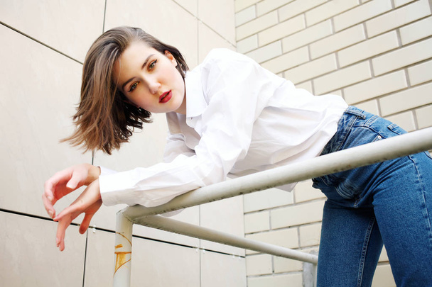 attractive woman posing on railing near building - 写真・画像