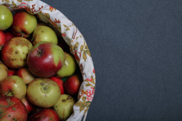 A large wicker basket with ripe juicy apples. New crop. On a gray background. View from above. - Фото, изображение