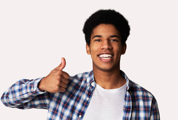 I like it. Happy afro guy showing thumb up gesture and smiling - Fotoğraf, Görsel