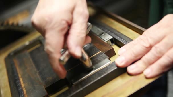 Bir letterpress yazıcı metal türü harfler tutan kovalamaca sıkılaştırmak için bir quoin anahtarı kullanır - Video, Çekim