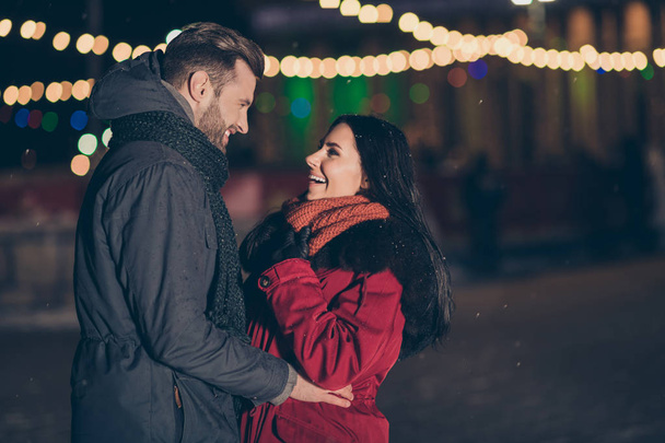 Two people in city park at newyear frosty midnight looking eyes magic atmosphere wearing warm winter coats and scarfs outside - 写真・画像