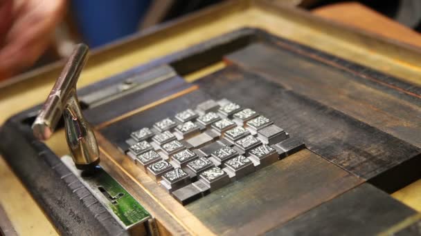 Una impresora aprieta un bloque de tipo con una tecla quoin
 - Imágenes, Vídeo