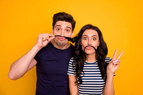 Photo of two fooling funky funny nice cute charming people husband and wife pretending to have mustaches with girlfriend showing v-sign while isolated with yellow background - Foto, immagini