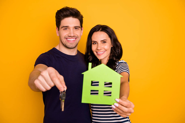 Photo of cheerful friendly couple of fallen in love offering you to buy new house cheaply while isolated with yellow background - Φωτογραφία, εικόνα