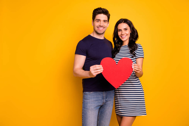 Photo of friendly nice charming beautiful couple of two people with girlfriend wearing dress and man jeans denim while isolated with yellow background - Фото, изображение