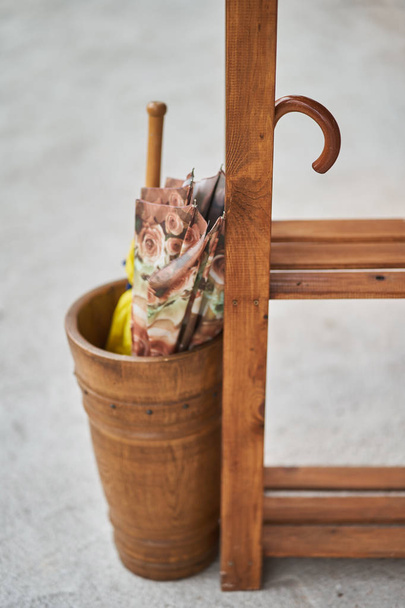 Dois guarda-chuvas dobrados em uma cesta de madeira
 - Foto, Imagem