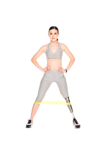 full length view of disabled sportswoman with resistance band isolated on white - Фото, изображение