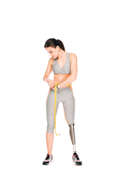 full length view of disabled sportswoman holding measure tape isolated on white - Foto, Imagem