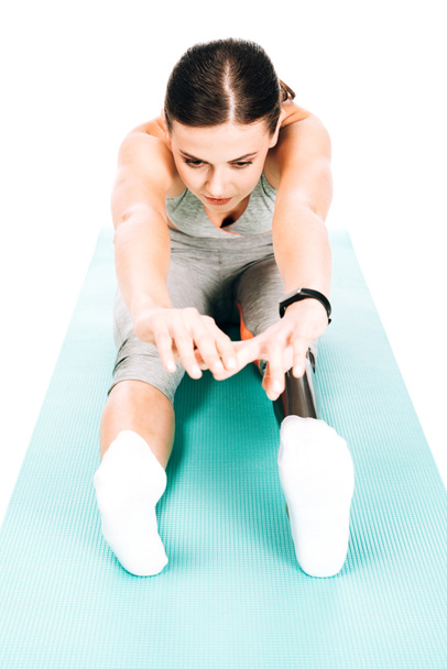 alacsony szög kilátás mozgássérült sportnő nyújtás fitness szőnyeg elszigetelt fehér - Fotó, kép
